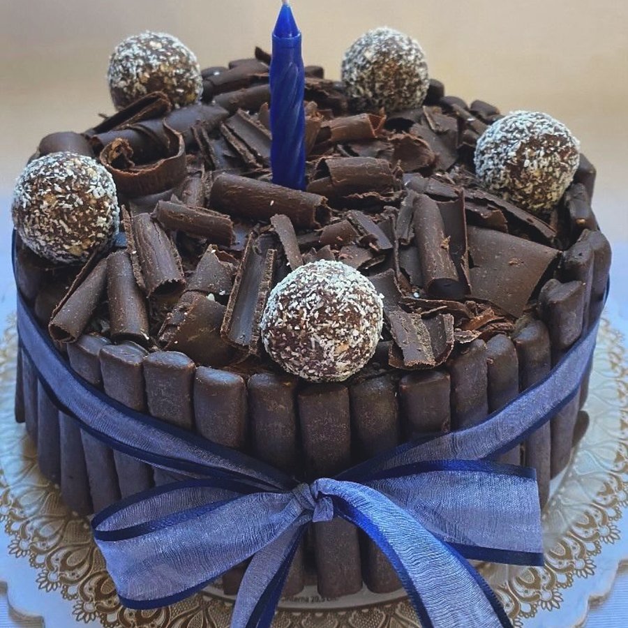 Torta de cumpleaños de chocolate con cigarrillos y moño azul