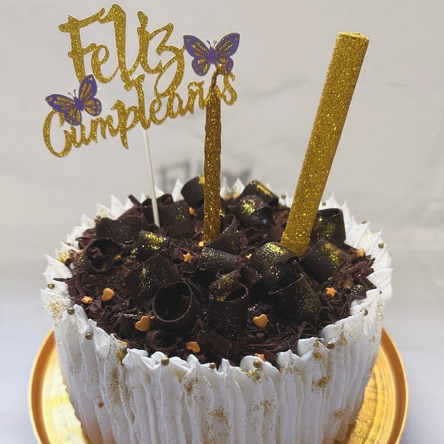 Torta de cumpleaños de merengue con rulos de chocolate y mariposas doradas